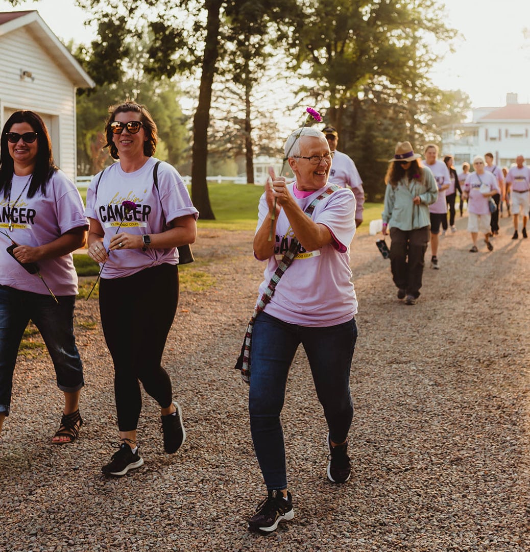 A group of people walking down a dirt road during the Kickin' Cancer Redwood County event.