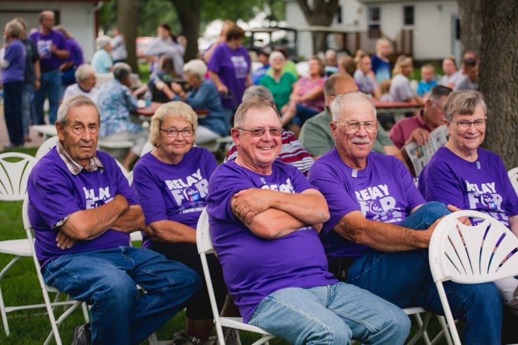 A group of people in purple shirts sitting in chairs.