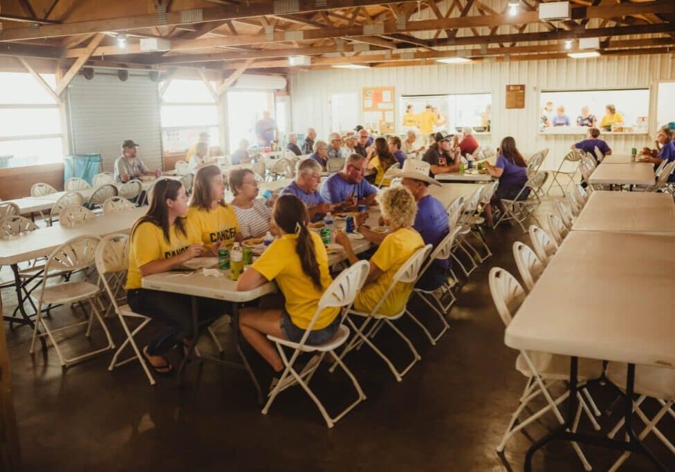 A support group sitting at tables in a large building.